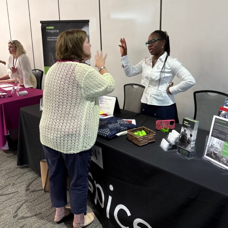 Two people talking over an exhibitor table