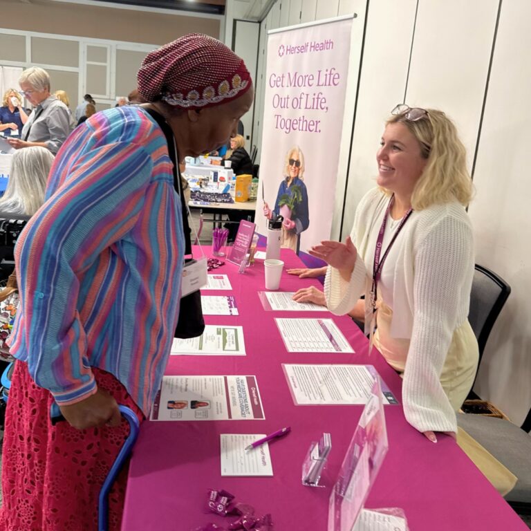 Two people talking over an exhibitor table