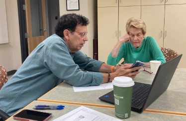 A man pointing something out on a cell phone.